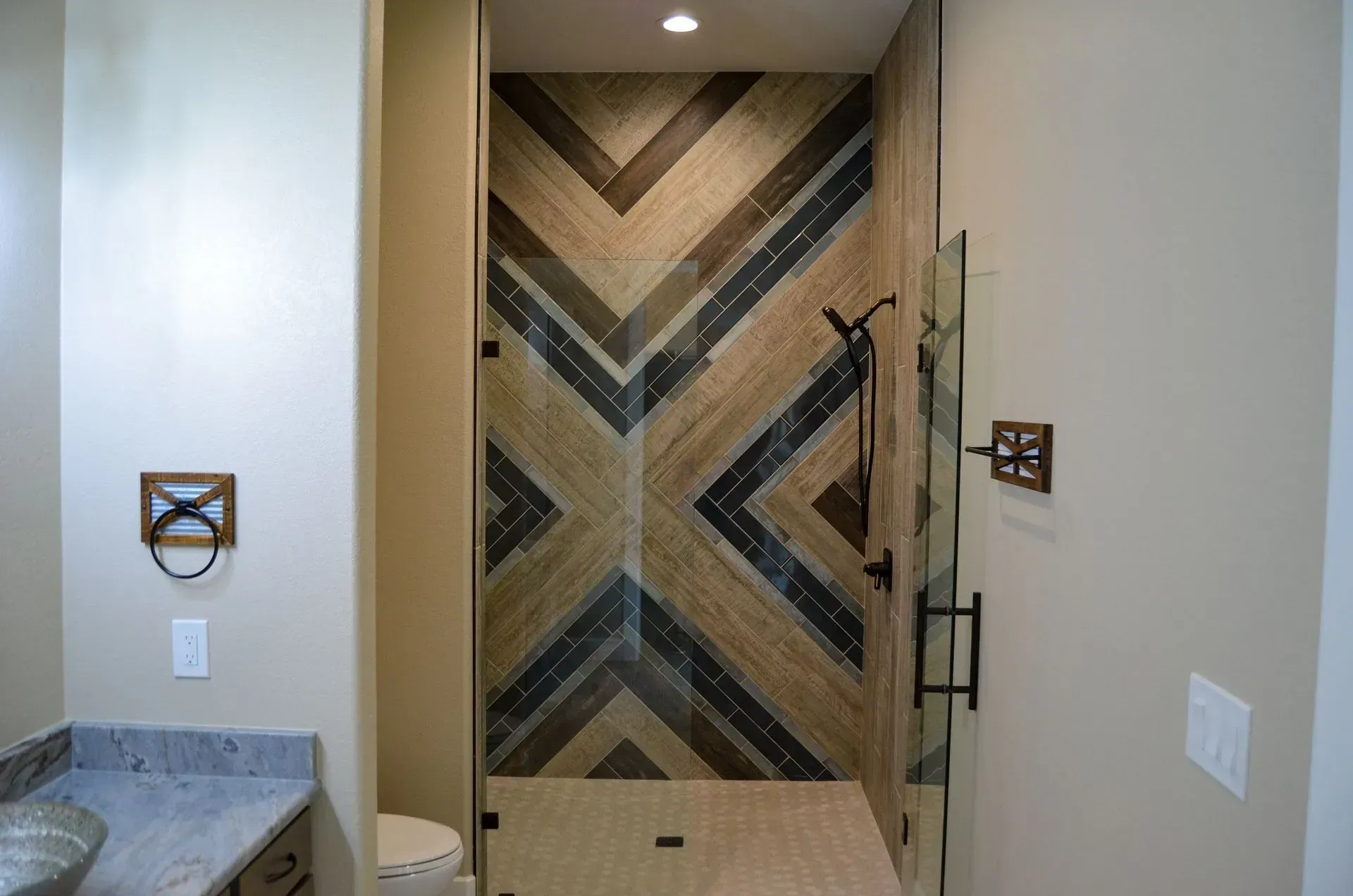 Bathroom with patterned wood tile shower enclosure and glass door.