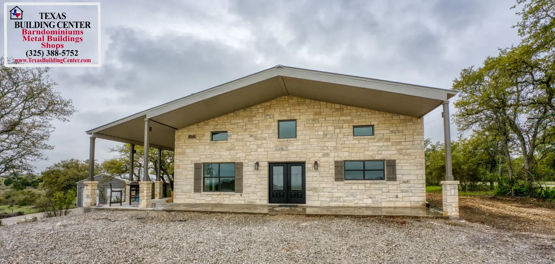Stone house with a porch under a cloudy sky.