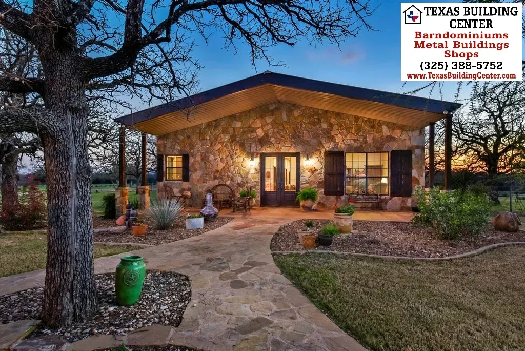Stone cottage at dusk, Texas Building Center. Path leads to front door, landscaping with greenery.
