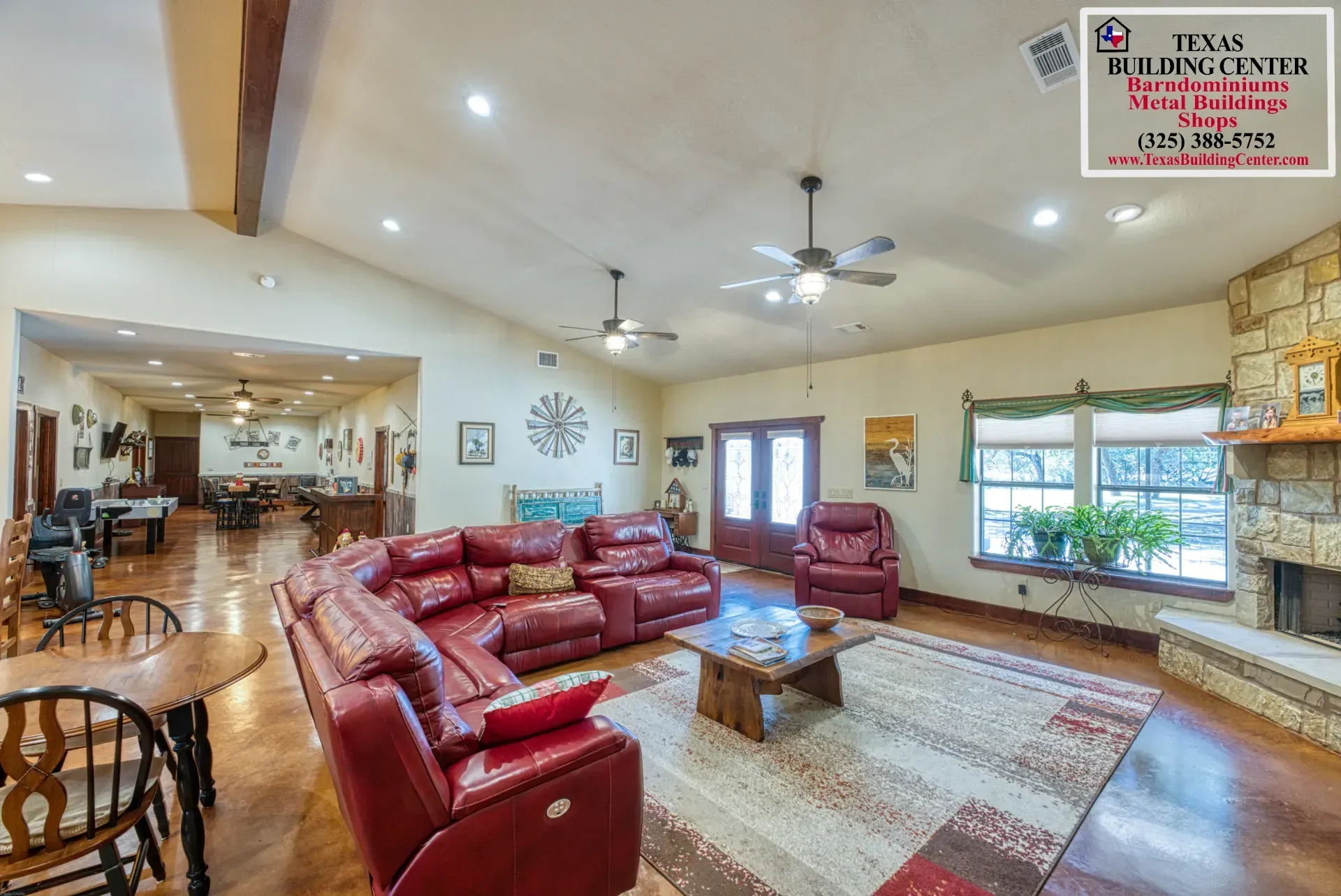 Spacious living room with red leather sectional, fireplace, and open to a dining area.