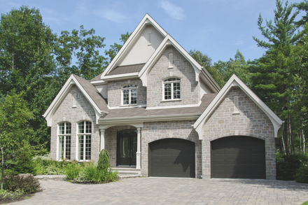A modern white house with a black garage door and a car parked in front of it.