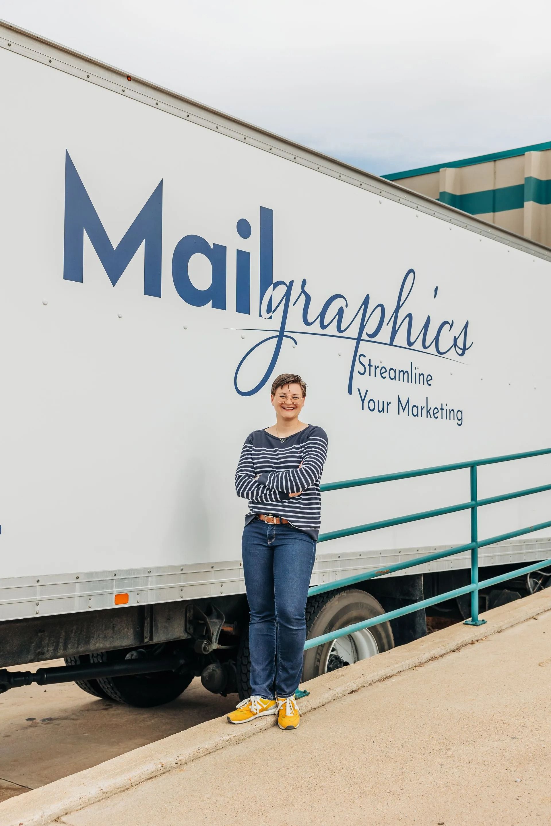 Woman stands beside a truck labeled 