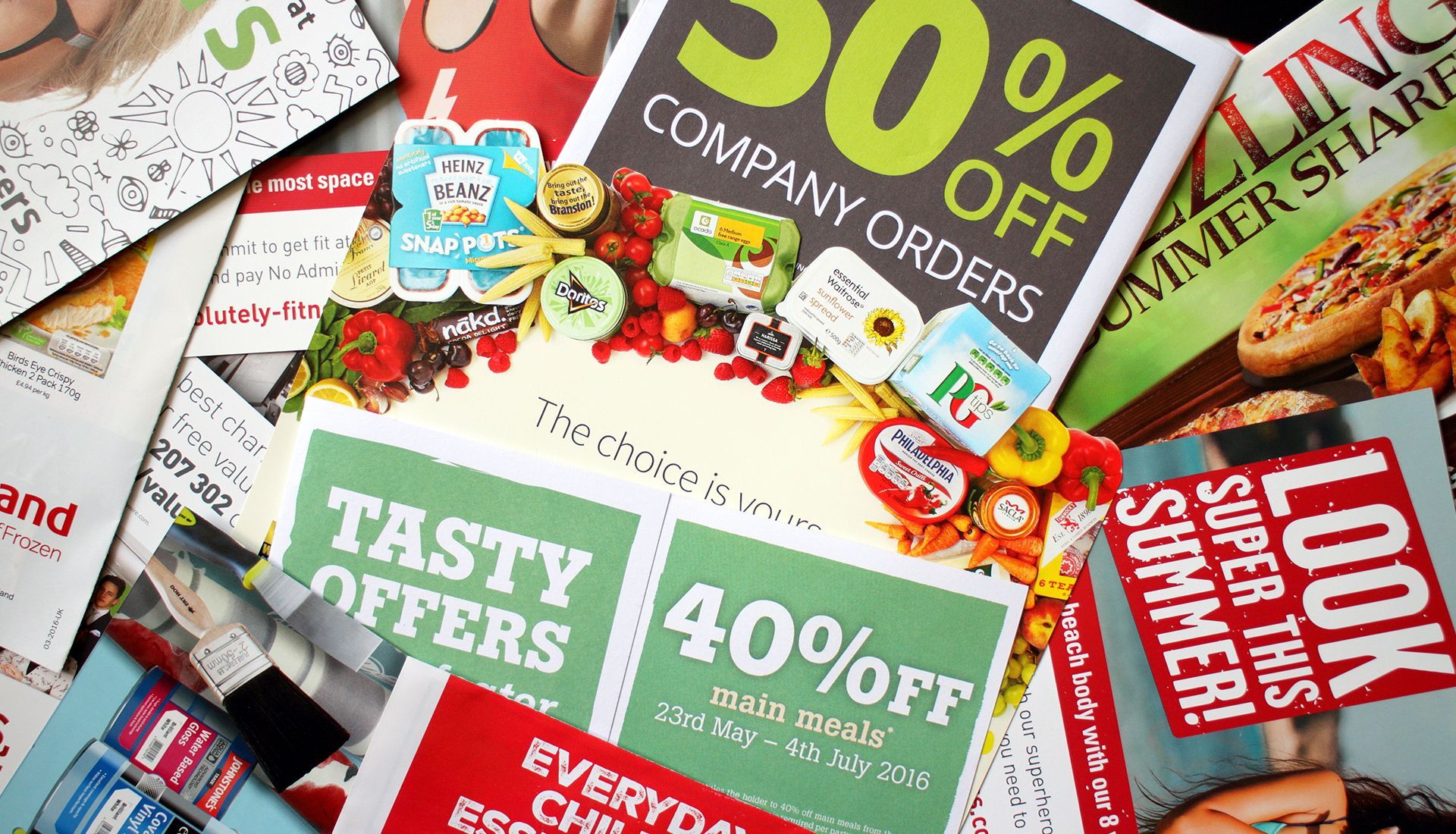 Open-concept living space with sectional sofa, kitchen, stairs, and ceiling fan.