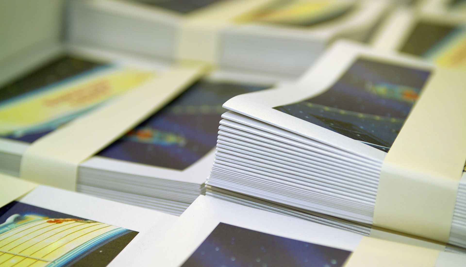 Open-concept living space with sectional sofa, kitchen, stairs, and ceiling fan.