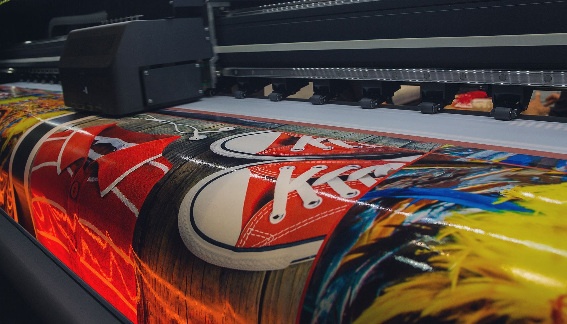 Large format printer printing colorful shoe designs.