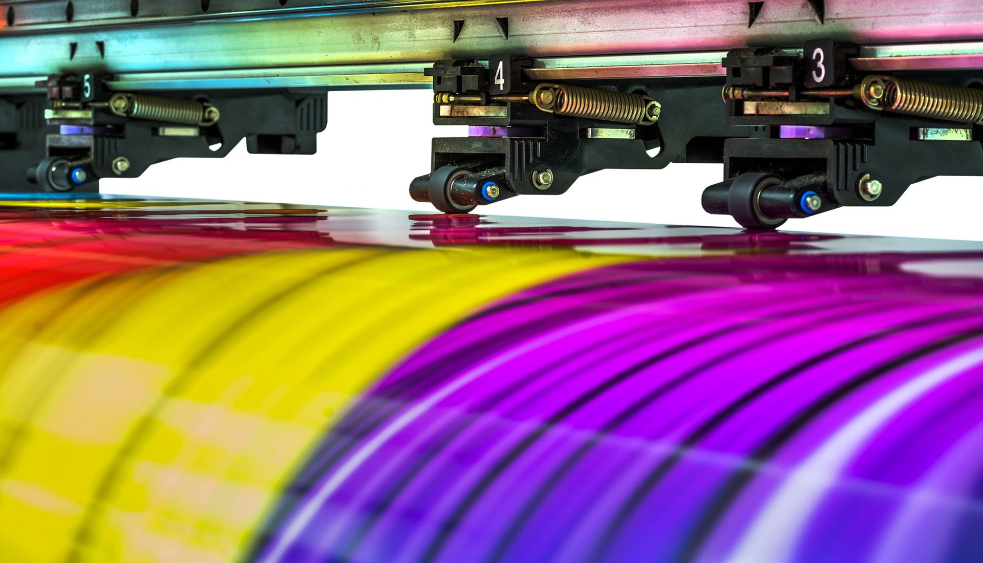 Open-concept living space with sectional sofa, kitchen, stairs, and ceiling fan.