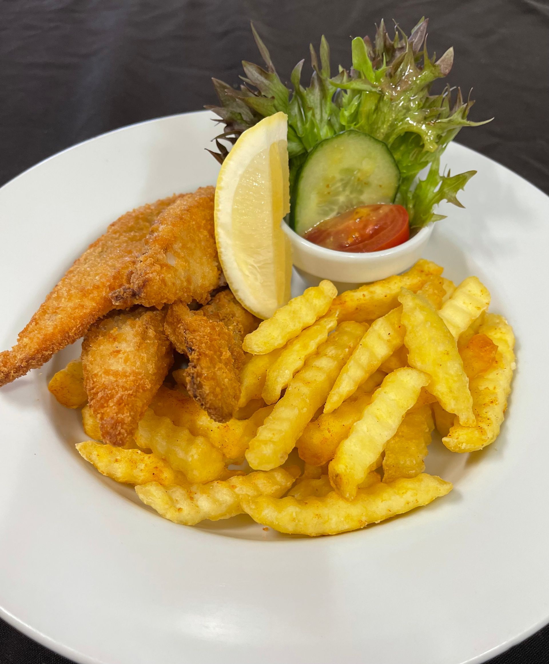 Stack of blueberry pancakes with syrup, whipped cream, and berry drizzle on a white plate.