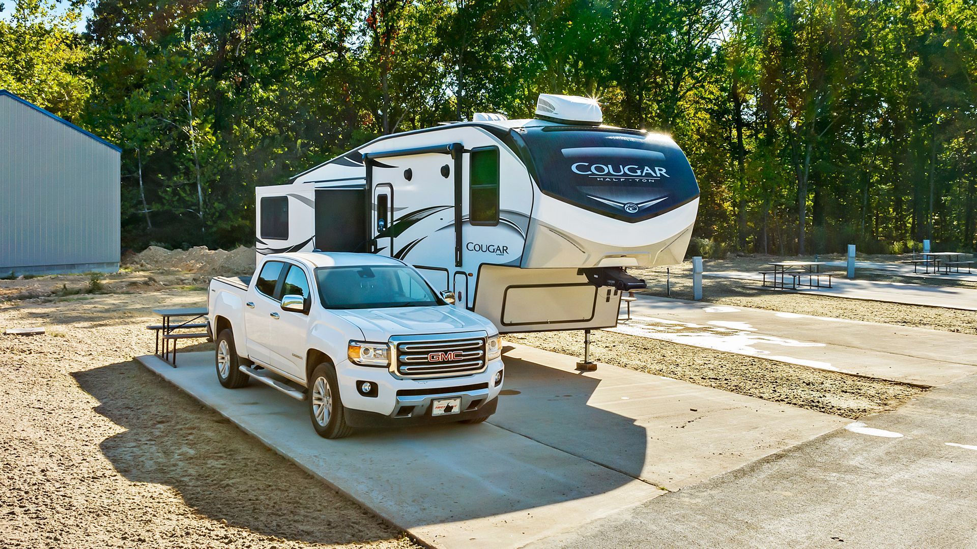 A rv is parked on the side of the road in front of a building.