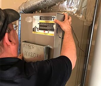 man fixing a heater - heating and air conditioning in Post Falls ID