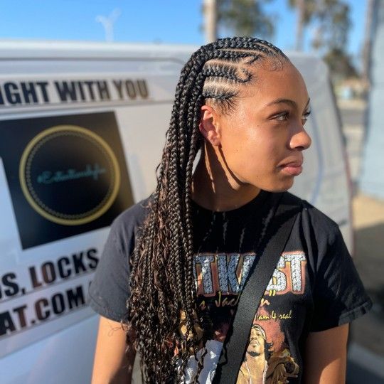 Woman with braided hairstyle, standing near a van with a logo.