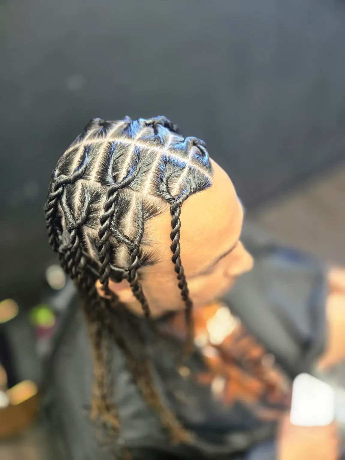 Braided hairstyle with a diamond-patterned top and twisted strands.