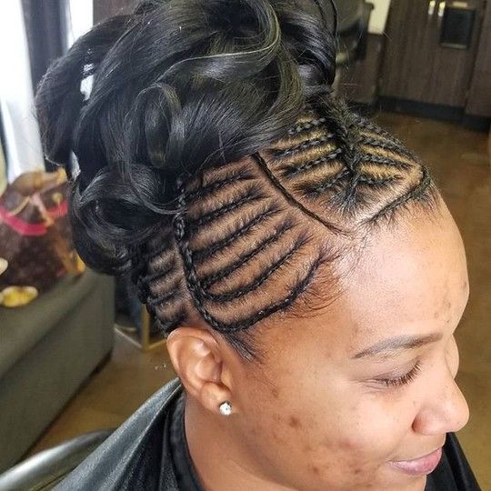 Woman with black braided hairstyle, pulled up in a bun. Braids are along the head's side.