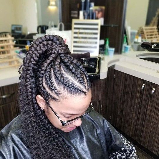 Person with braided hairstyle in a salon setting. Braids are pulled back into a high ponytail.