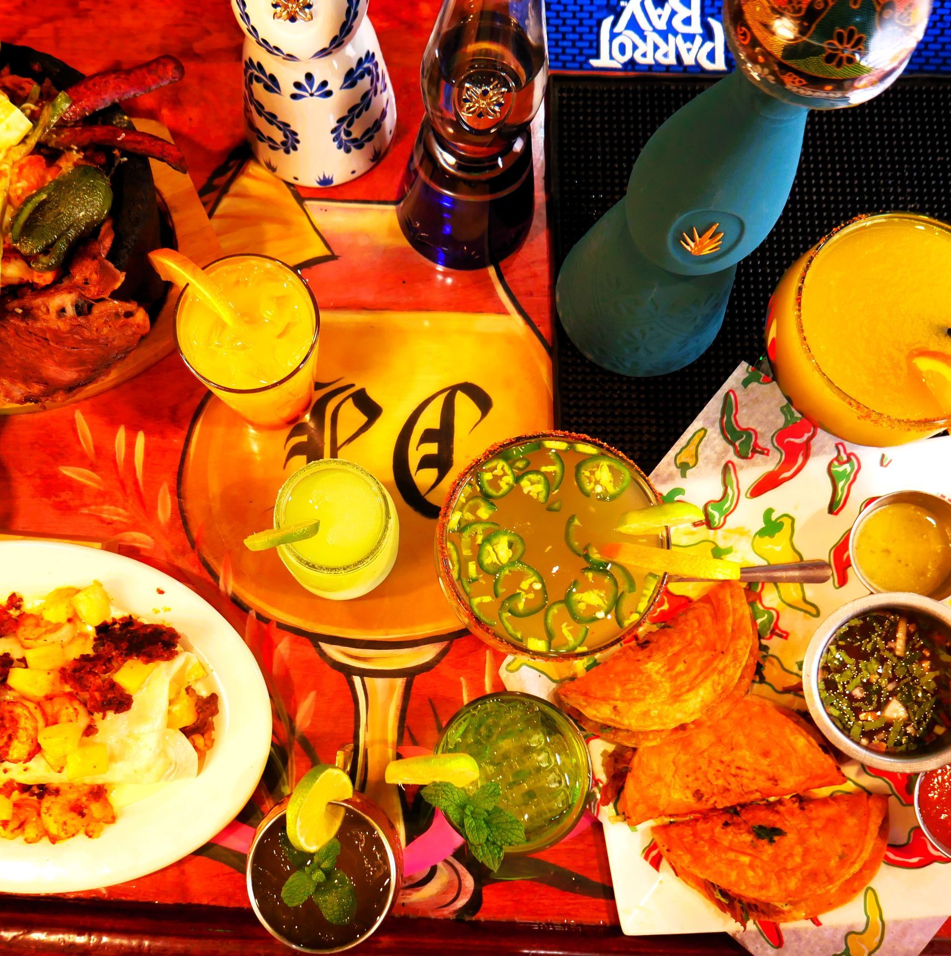 A tray of food and drinks on a table with a parrot pay sign in the background