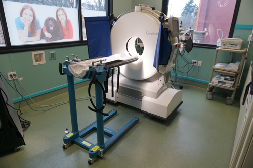 A ct scan machine is sitting in a room next to a window.
