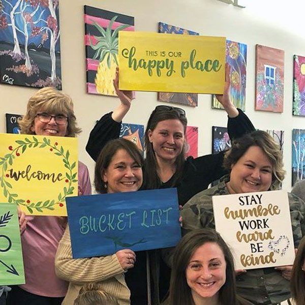 group of ladies holding their paintings