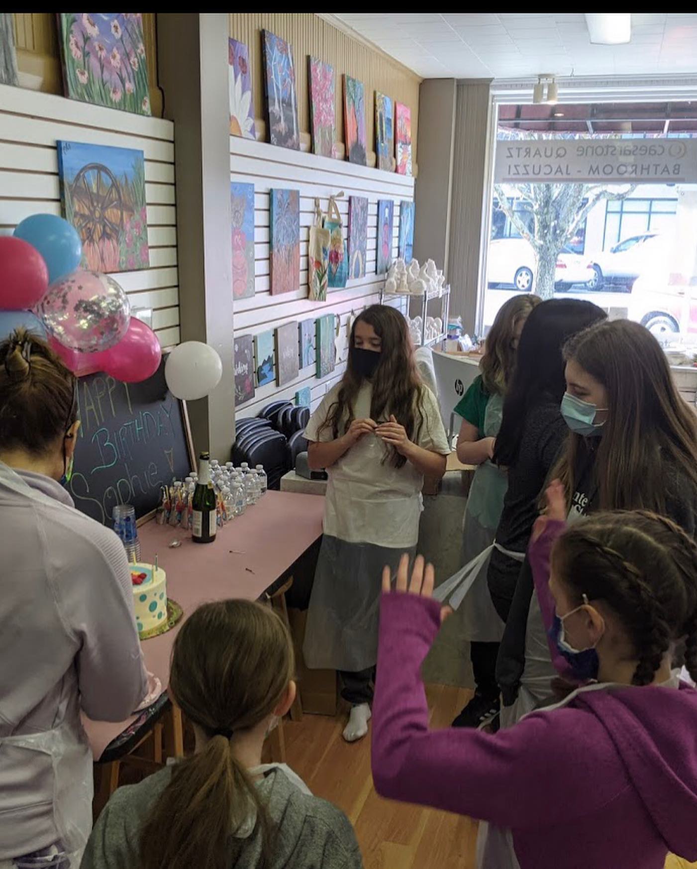 kids celebrating birthday with cake in art studio
