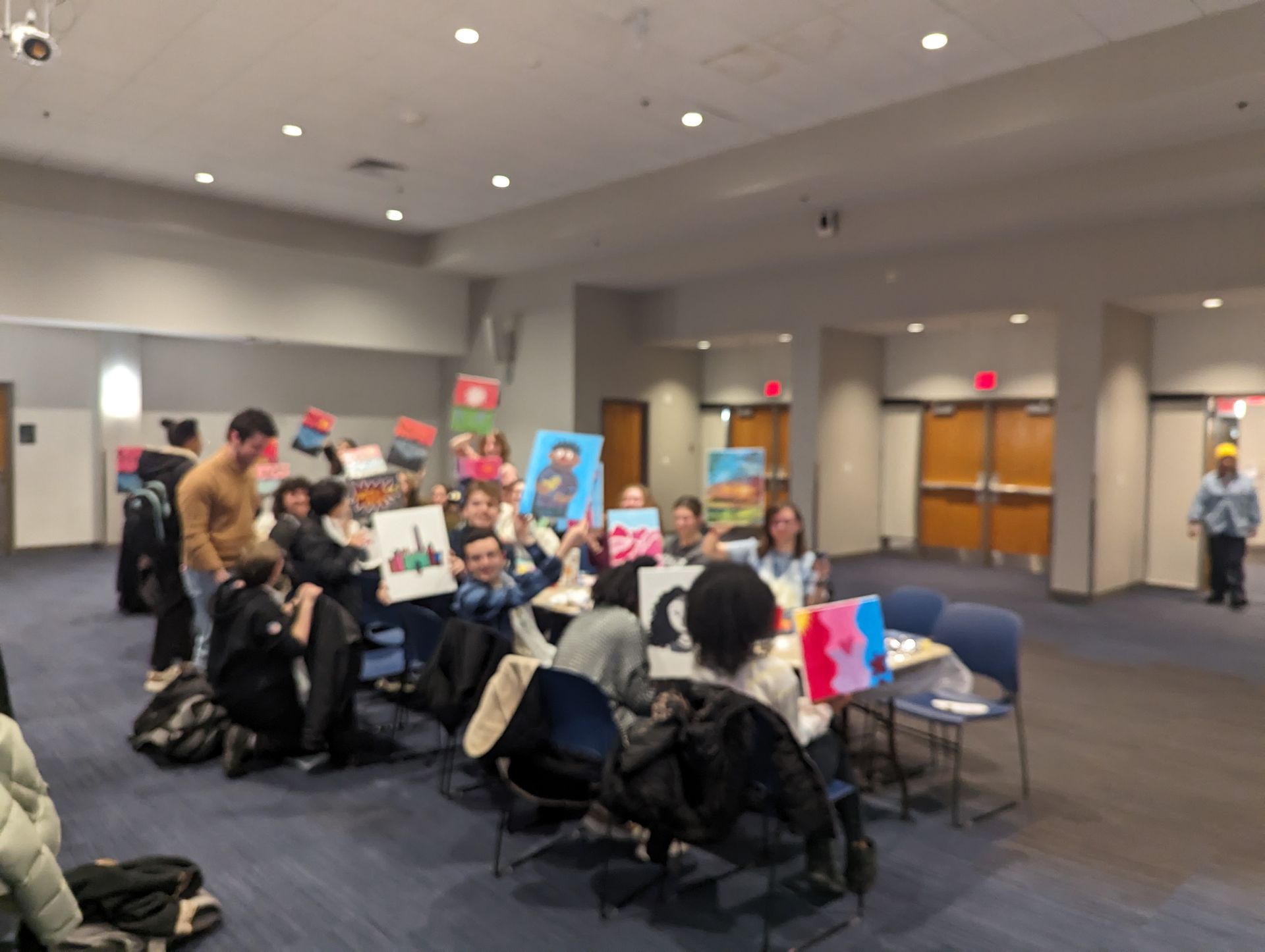 A group of people are sitting around a table holding signs