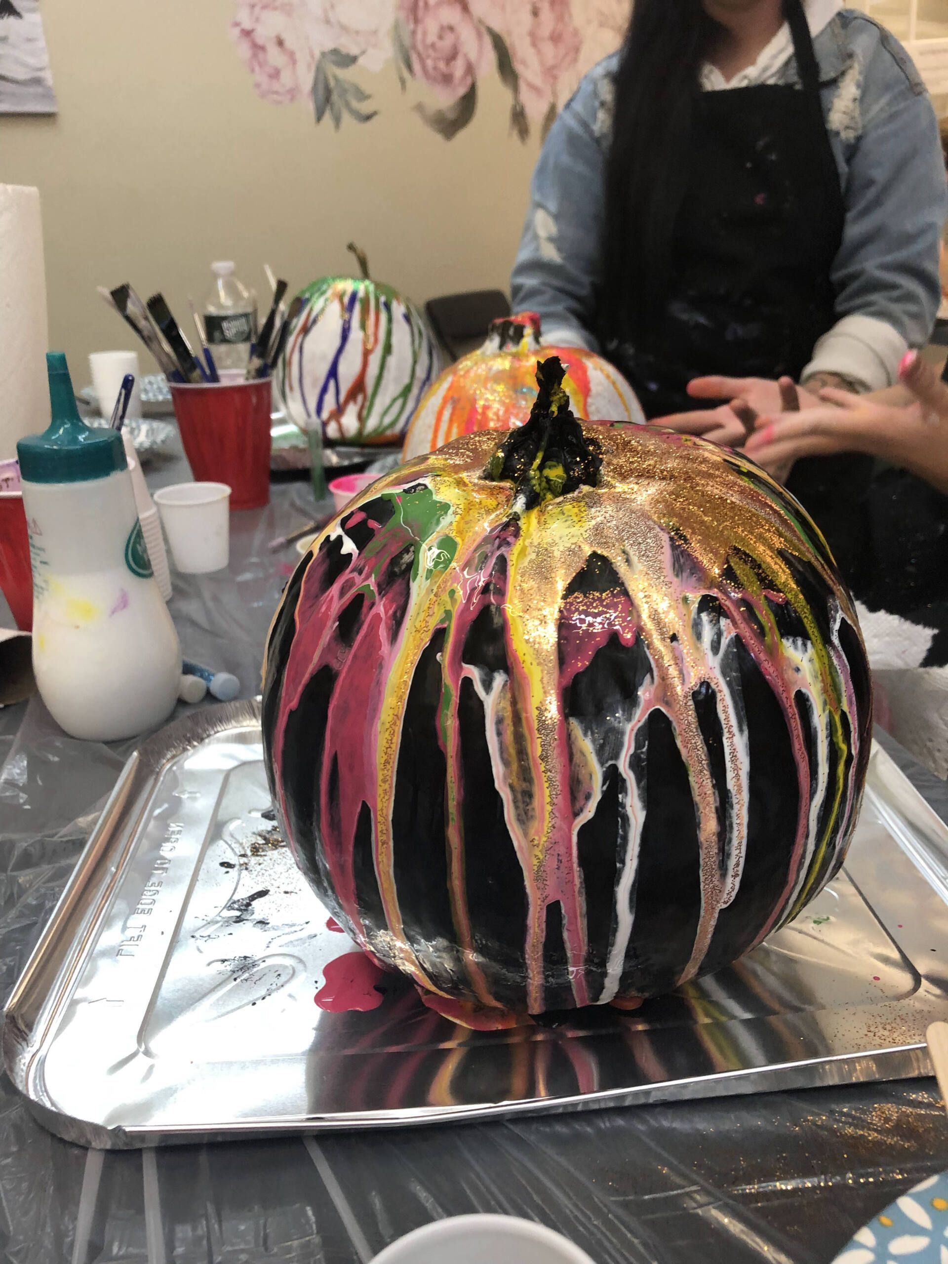 A pumpkin is sitting on a metal tray on a table