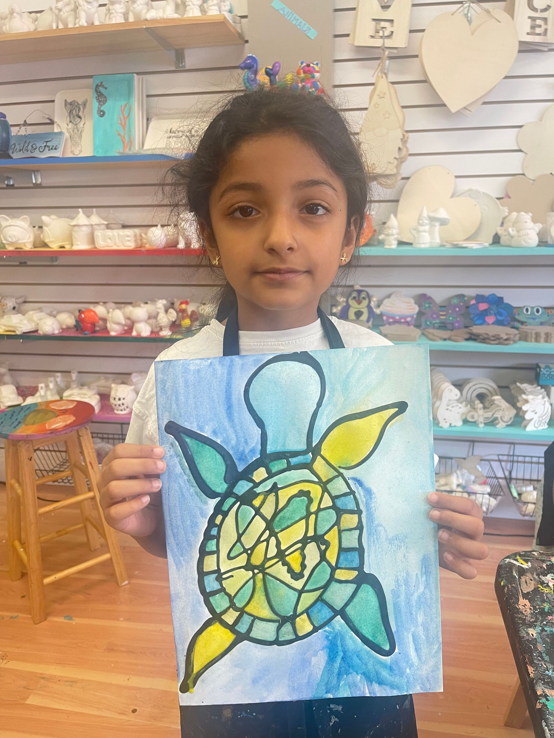 two girls holding their painted canvas