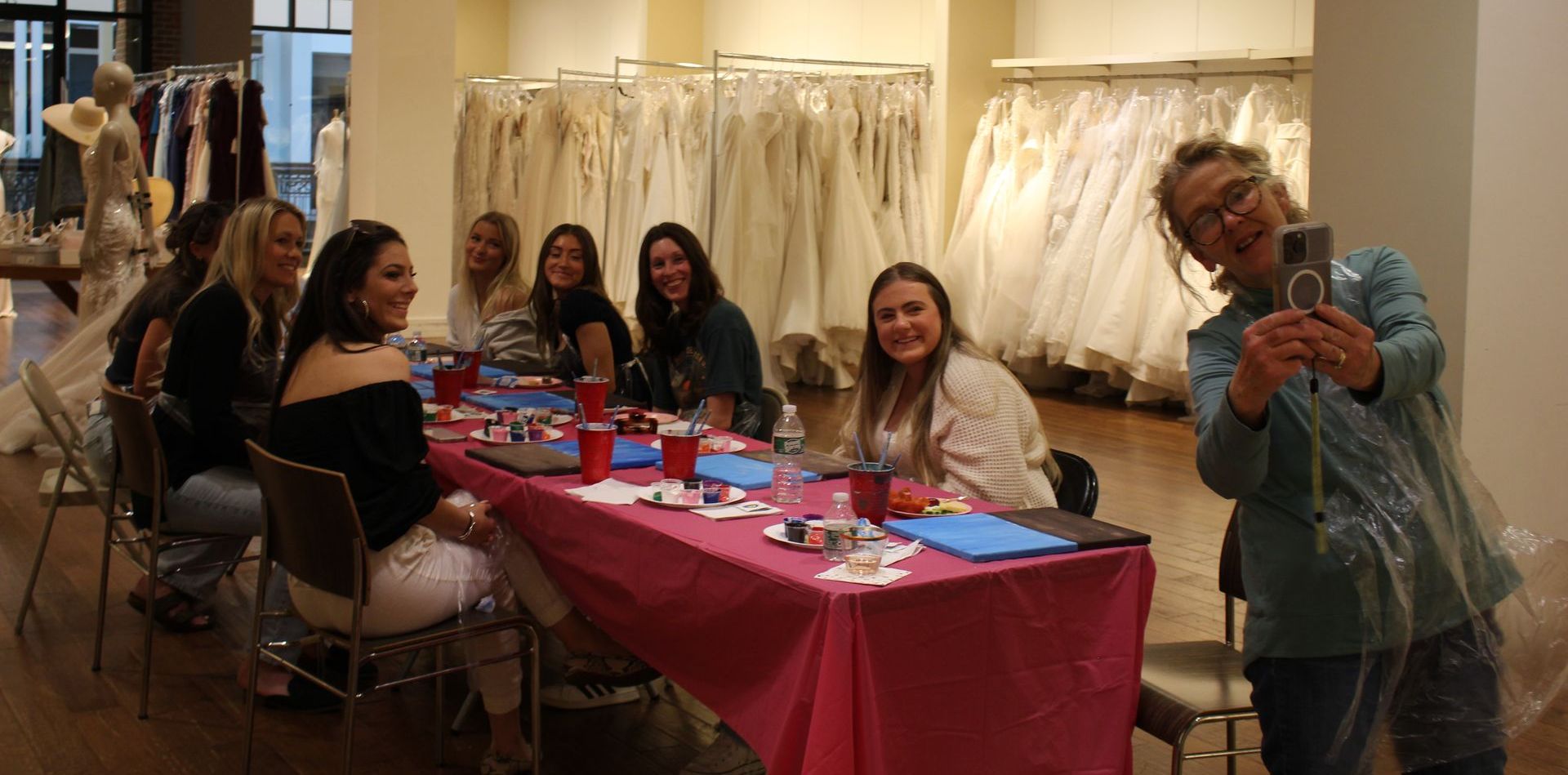 A woman is taking a picture of a group of women sitting at a table.