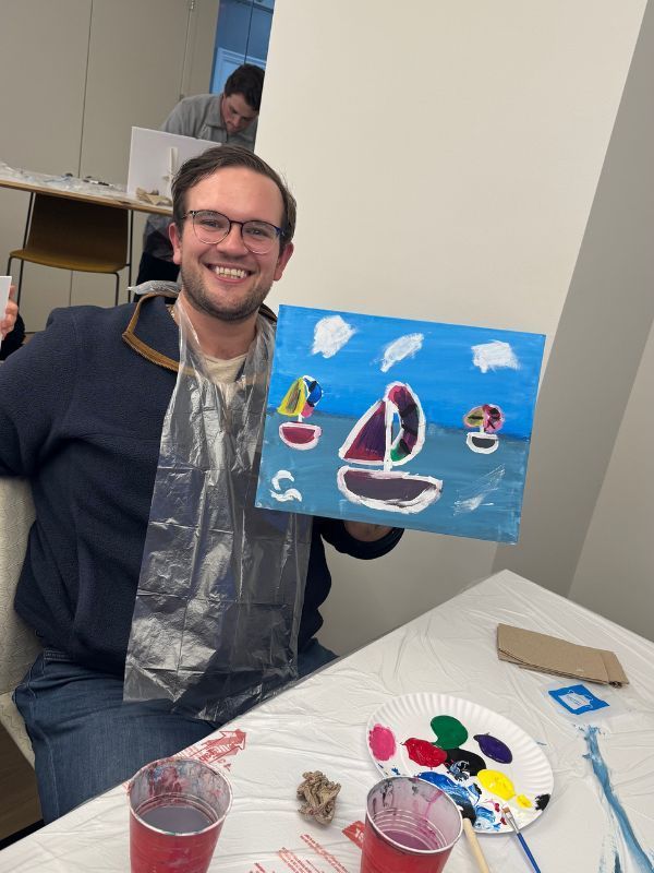 Two women posing with painted clocks