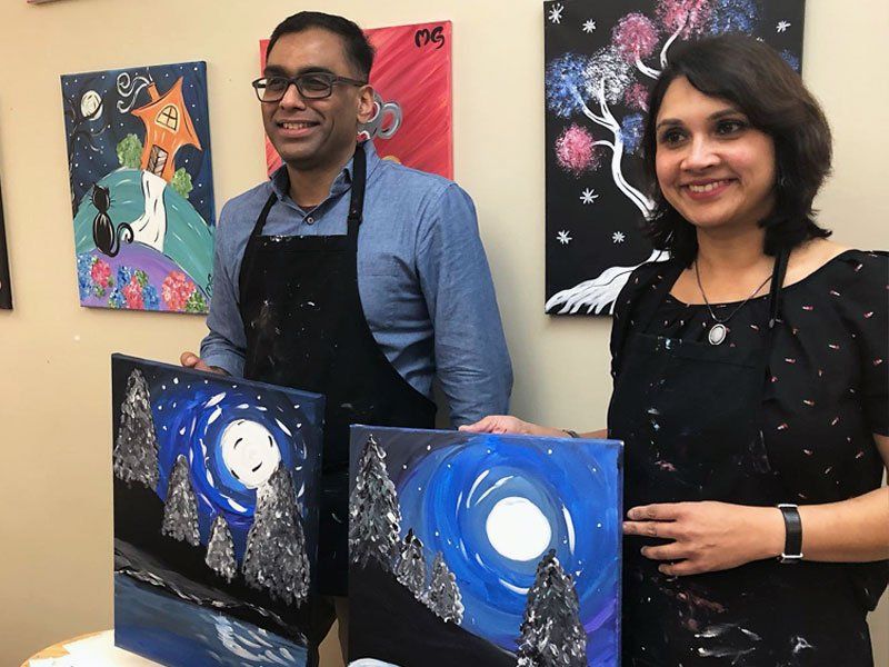 Couple Holding Paintings