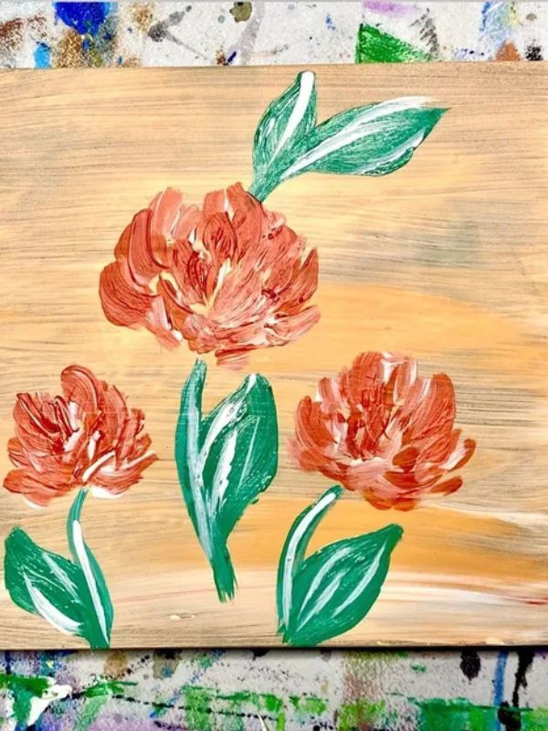 A painting of three red flowers with green leaves