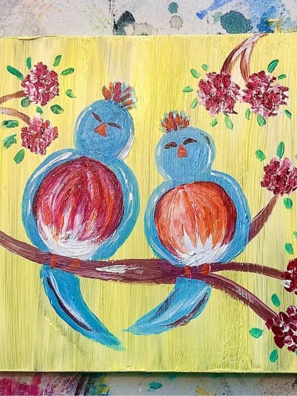 A painting of two birds sitting on a branch with flowers.