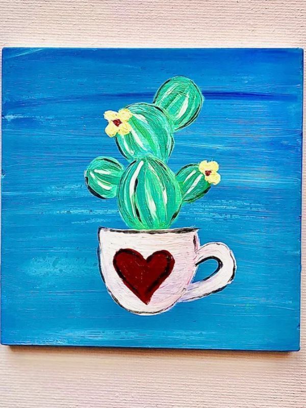 A painting of a cactus in a cup with a heart on it.