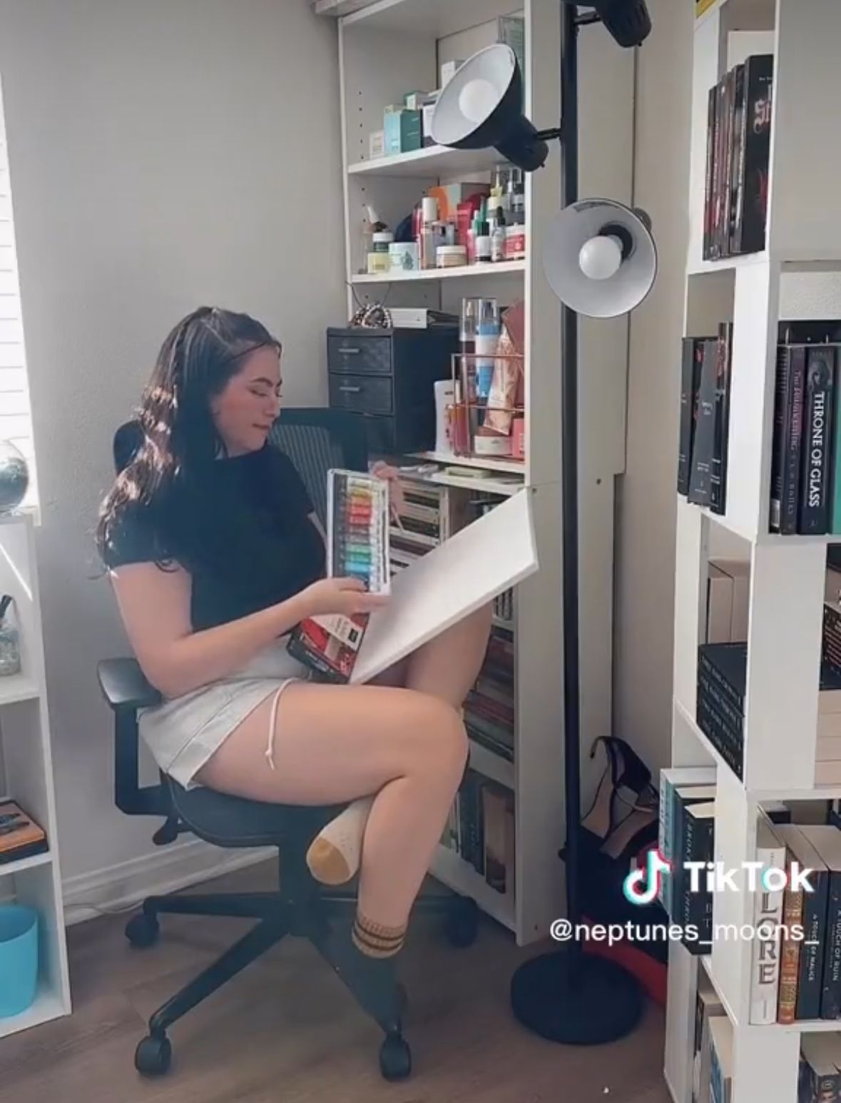 A woman is sitting in a chair reading a book.