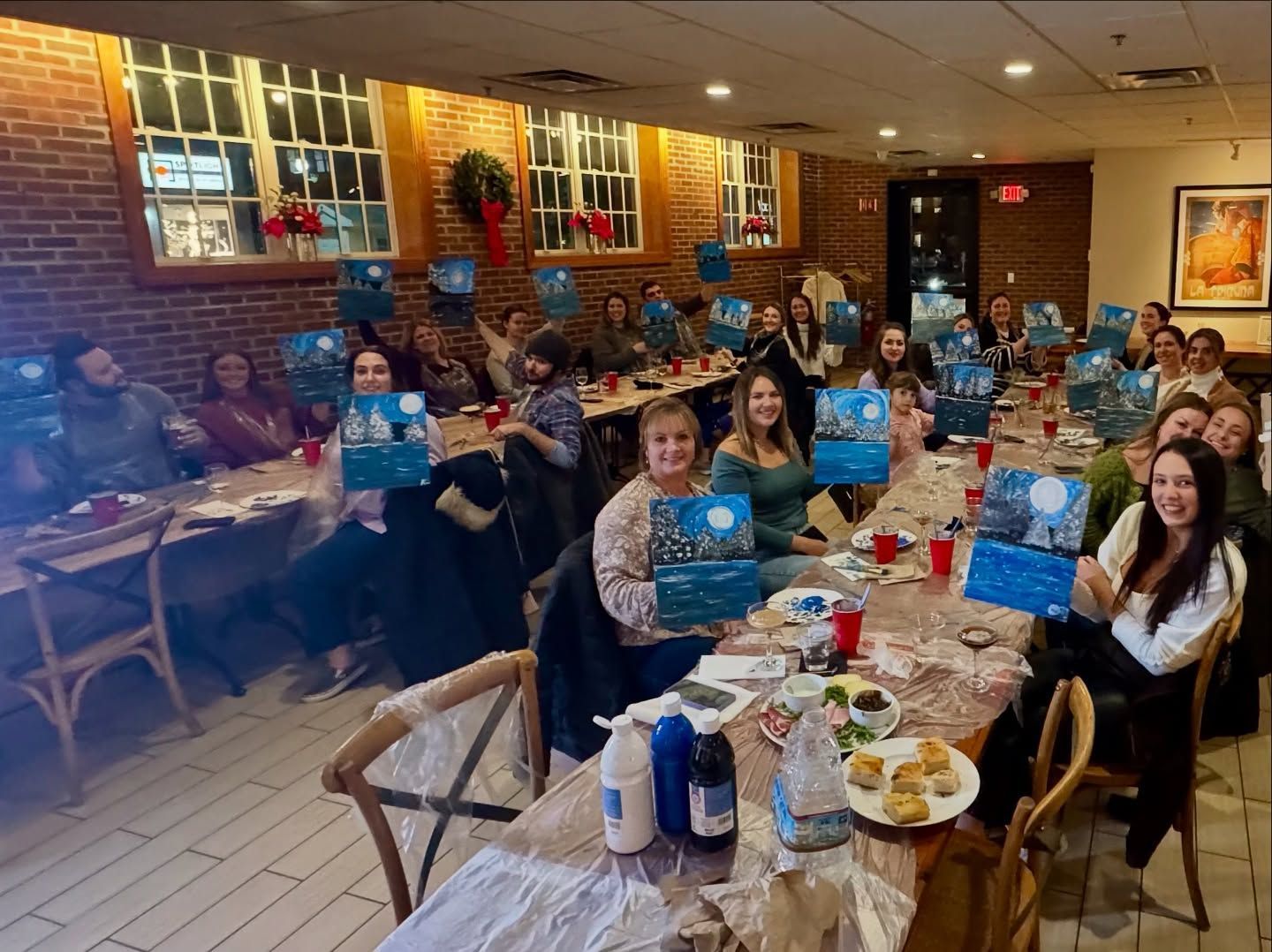 A group of people are sitting at long tables in a restaurant.
