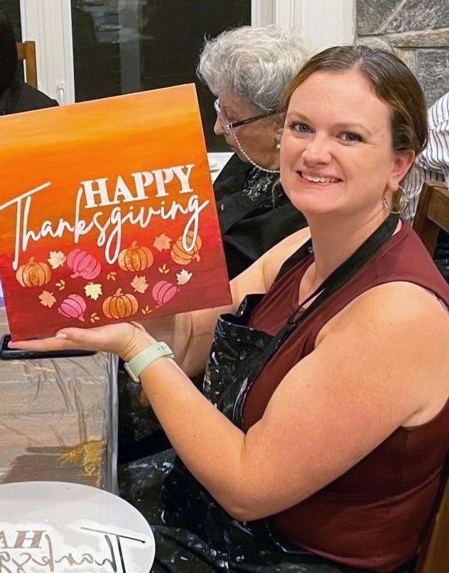 woman holding happy thanksgiving painting