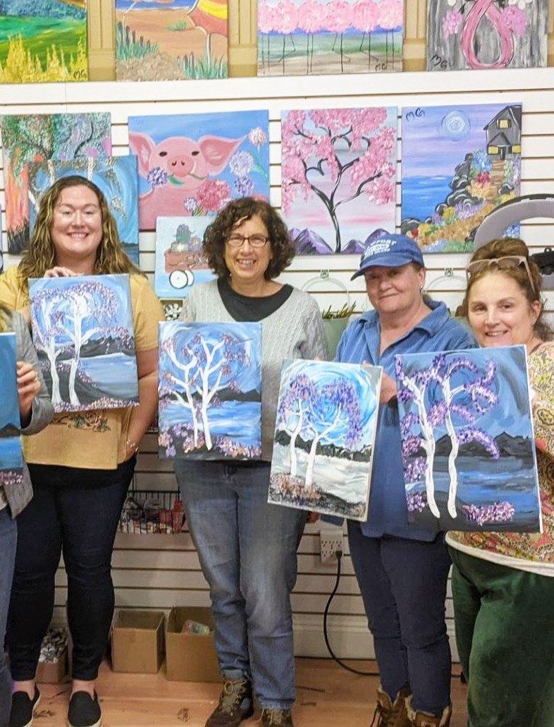 ladies holding their own paintings