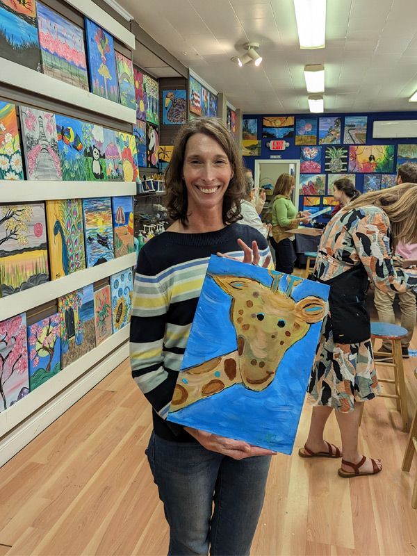 woman holding giraffe painting