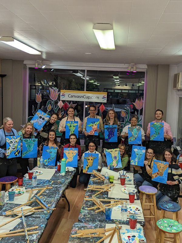 group posing withpaintings of giraffes