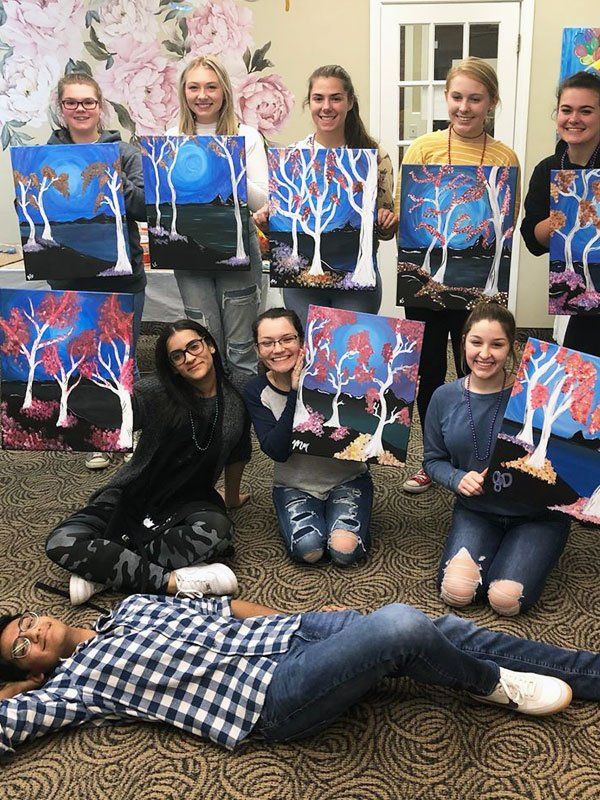 group class posing with tree canvas paintings