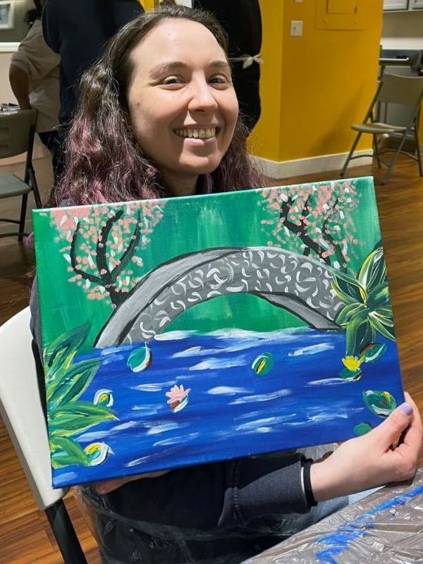 woman holding a bridge painting