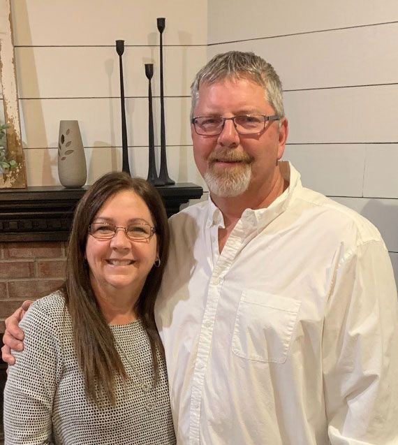 Plumber Dave and his wife Julie,  standing next to each other and smiling