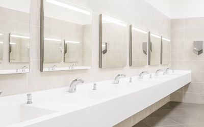 a public restroom with a long row of sinks and mirrors