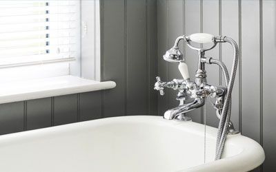 a bathtub with a shower head attached to it in a bathroom