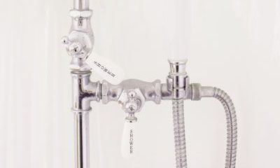 a close-up of a shower head fixture with a hose attached to it