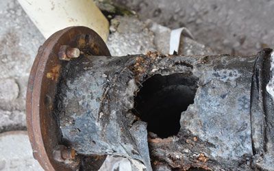 a close up of a rusty pipe with a hole in it