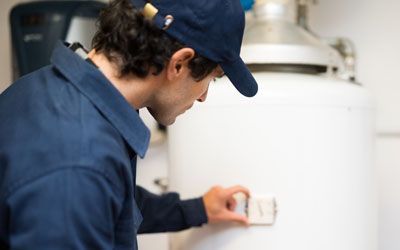 a man is adjusting a thermostat on a water heater