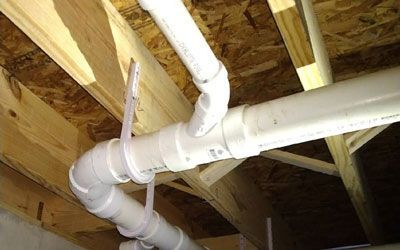 a bunch of white pipes are hanging from the ceiling of a house