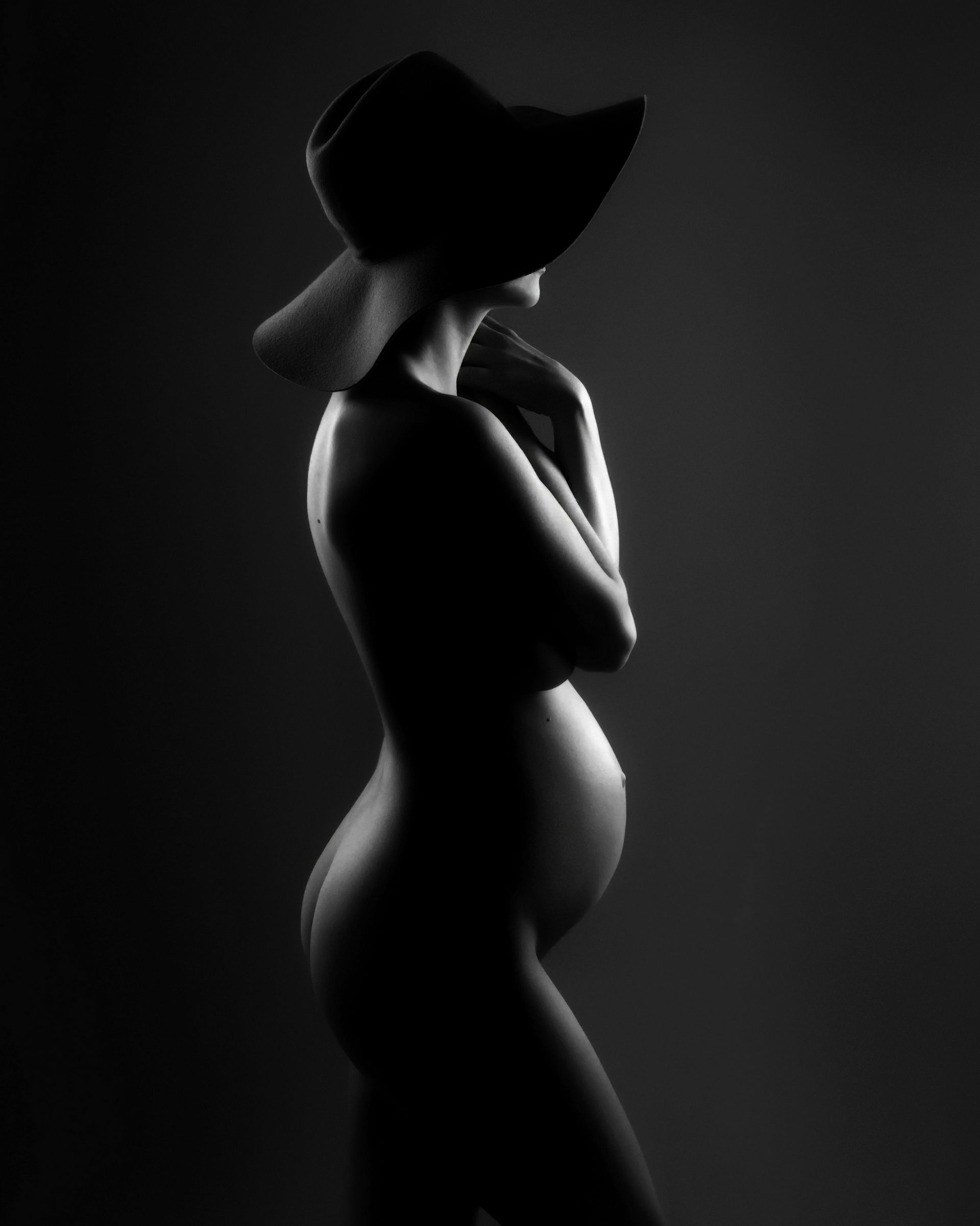 Hele mooie zwart-wit foto van een zwangere vrouw tijdens een zwangerschapsshoot