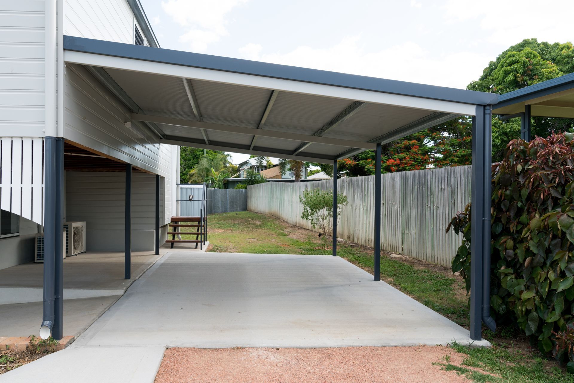 There is a carport in the backyard of a house.
