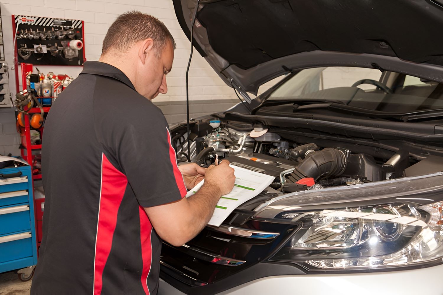 A Man Is Working on The Engine of A Car — Wayne's Mechanical World in Pialba, QLD