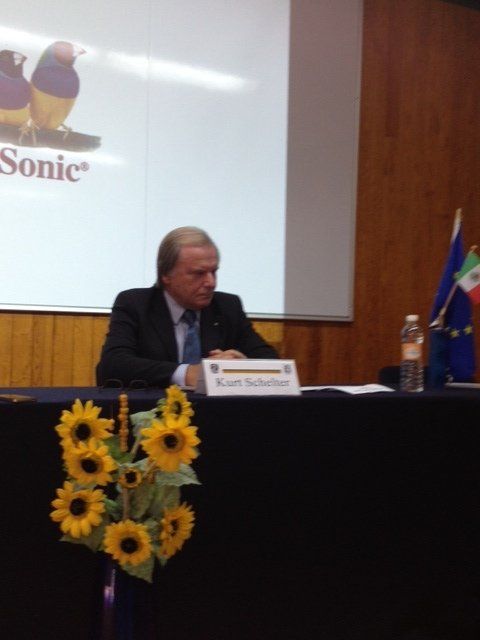 Ein Mann sitzt an einem Tisch vor einem Bildschirm mit der Aufschrift „Sonic“