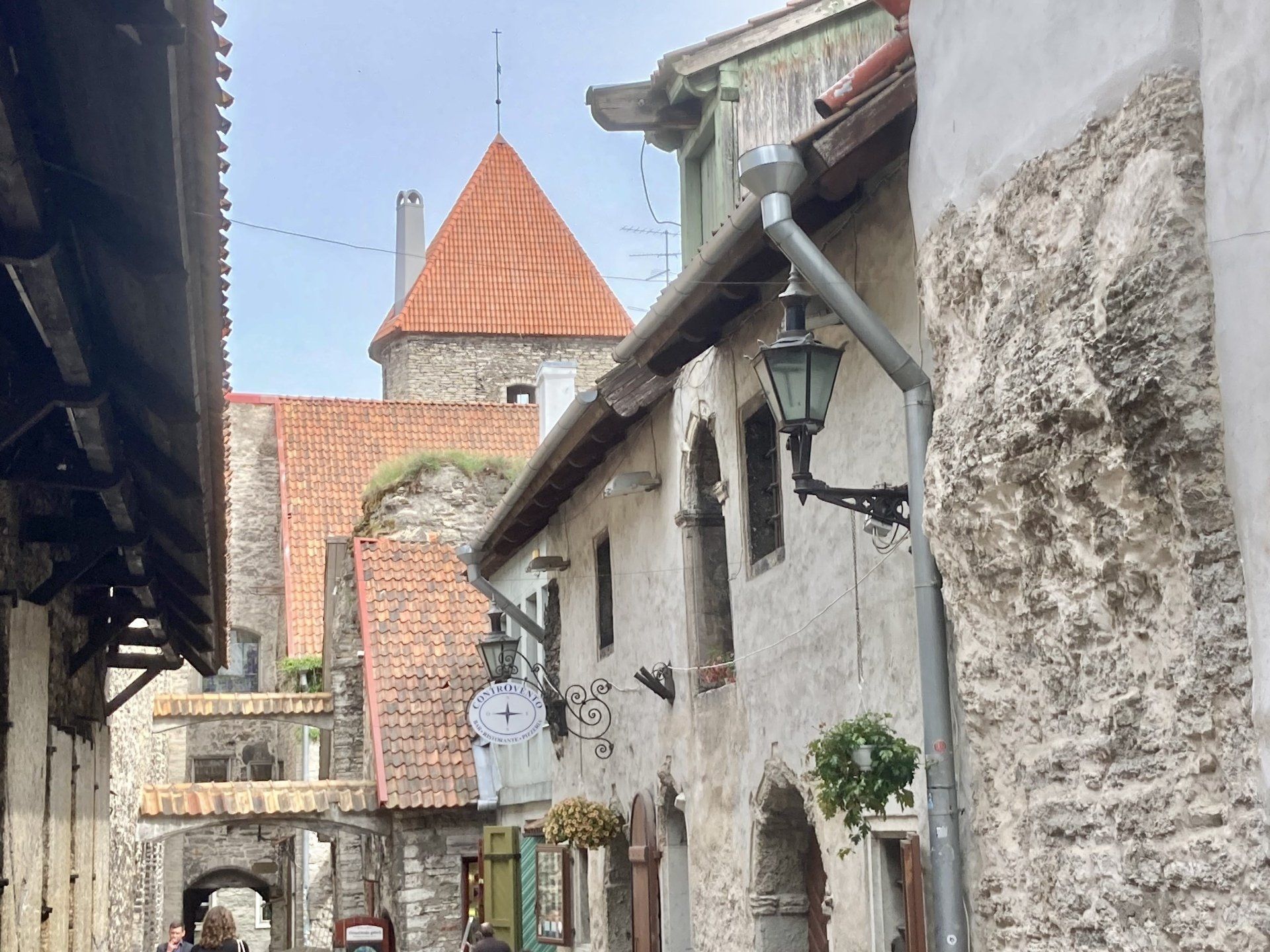Eine schmale Straße mit einem Backsteinturm im Hintergrund